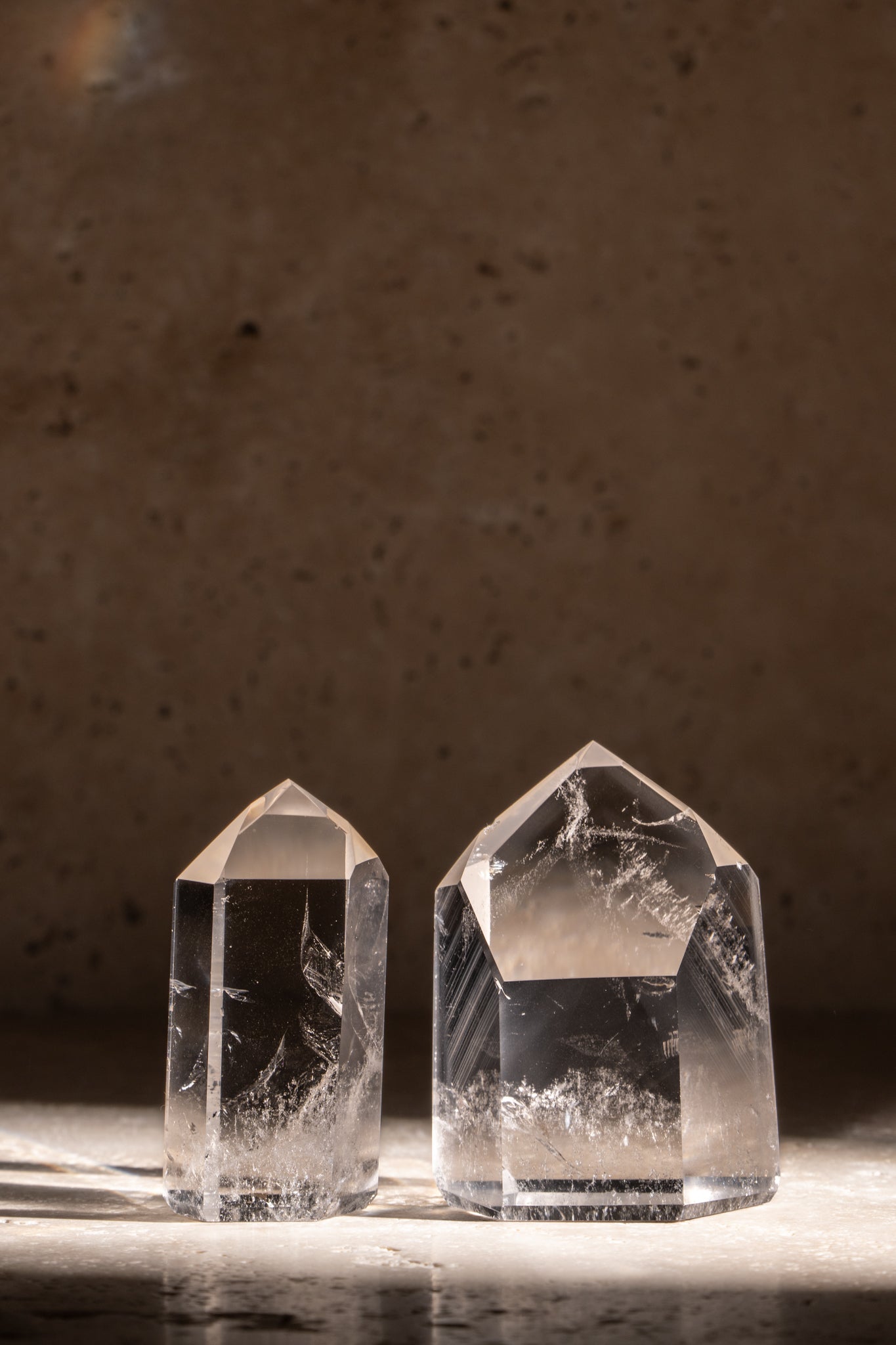 Two polished AAA quality Clear Quartz towers with sharp, faceted tips, showcasing exceptional clarity and smooth surfaces.