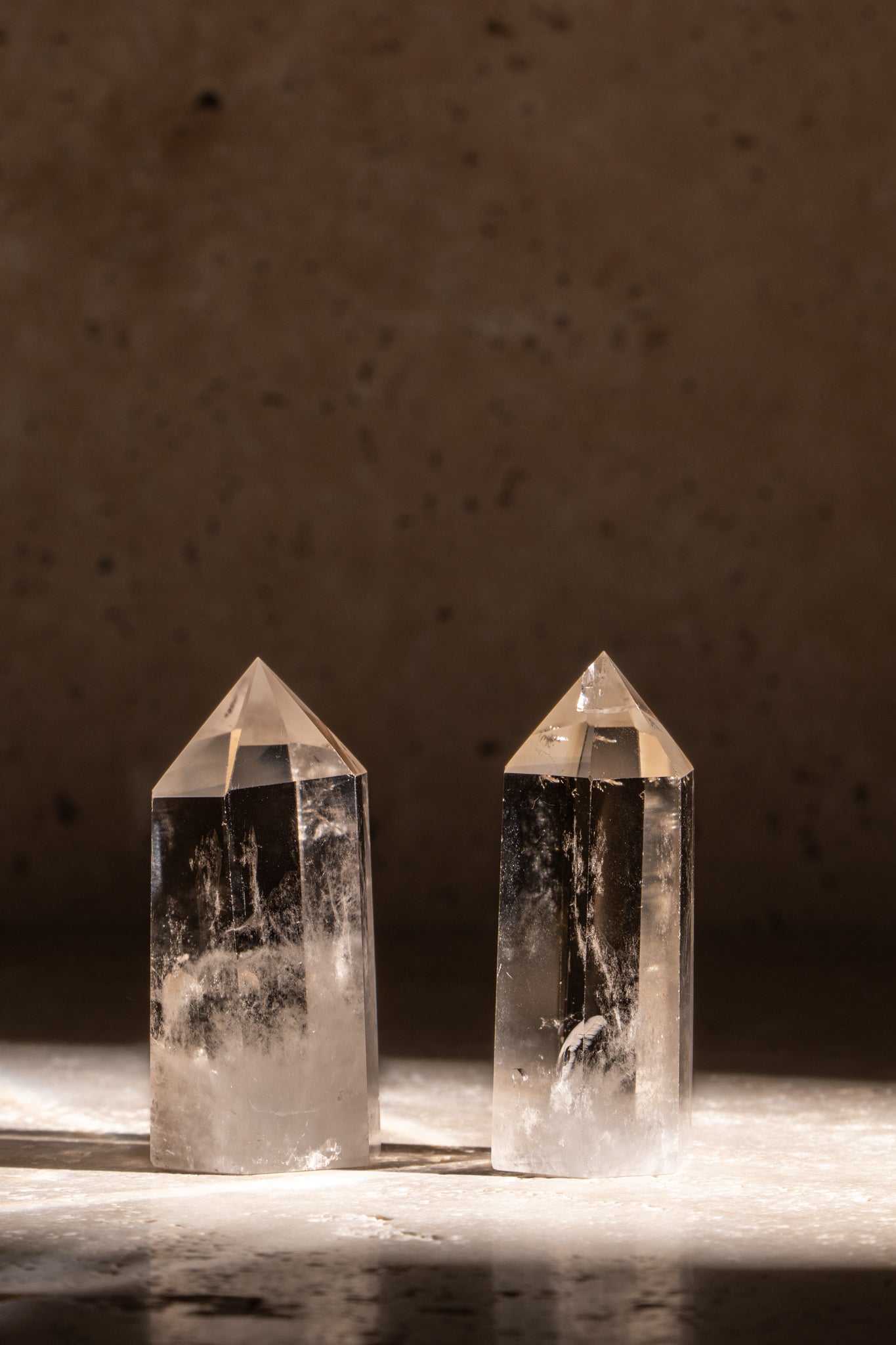 A set of two polished AAA quality Clear Quartz towers, featuring faceted tips and natural inclusions, radiating clarity and light.