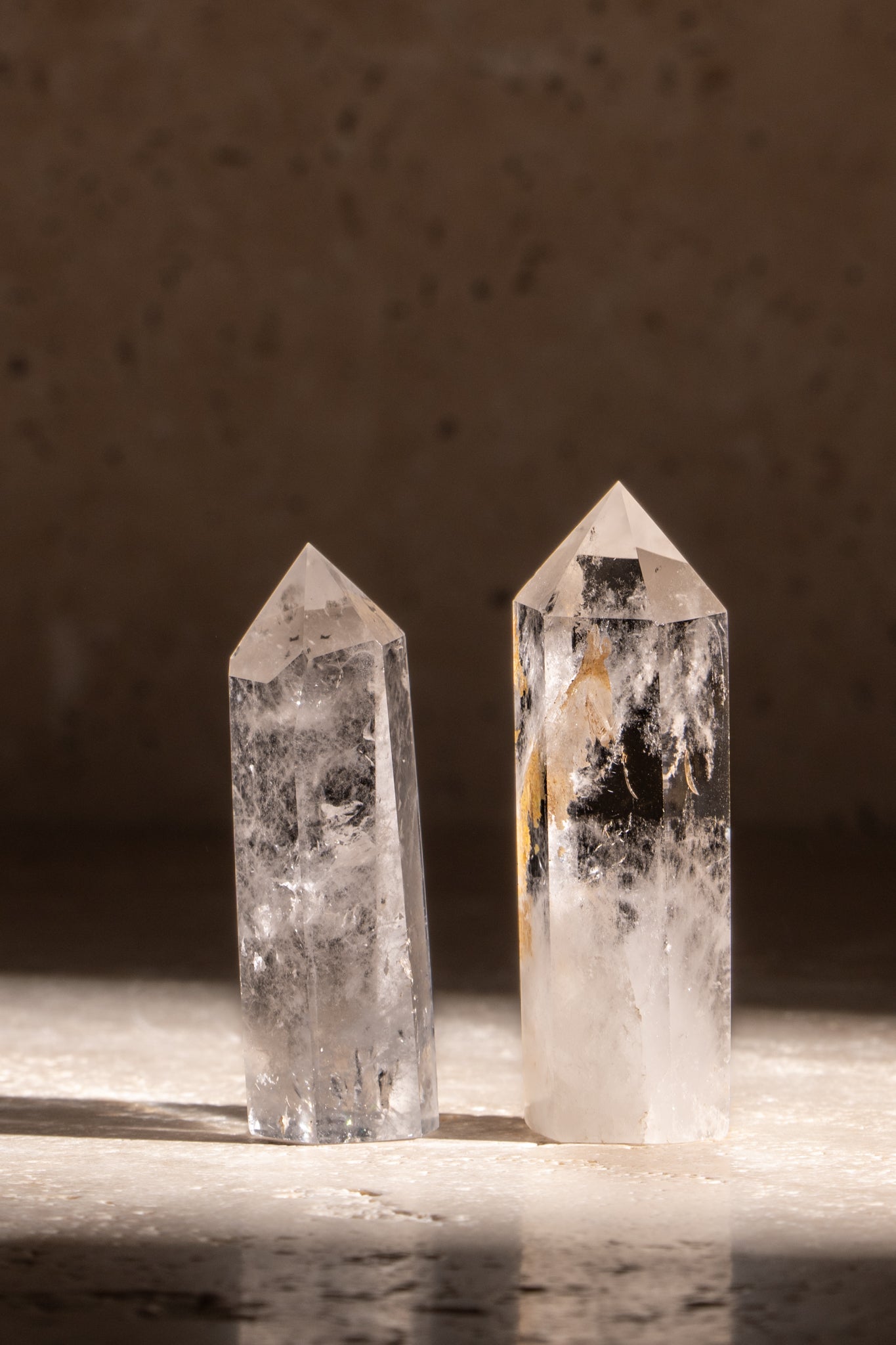 A set of two polished AAA quality Clear Quartz towers, each featuring faceted tips with stunning clarity and natural inclusions, enhancing any space with positive energy.