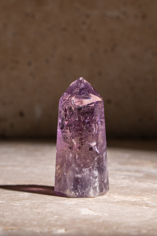 A natural Amethyst crystal tower with rich purple hues and unique inclusions, designed to bring soothing energy and balance.