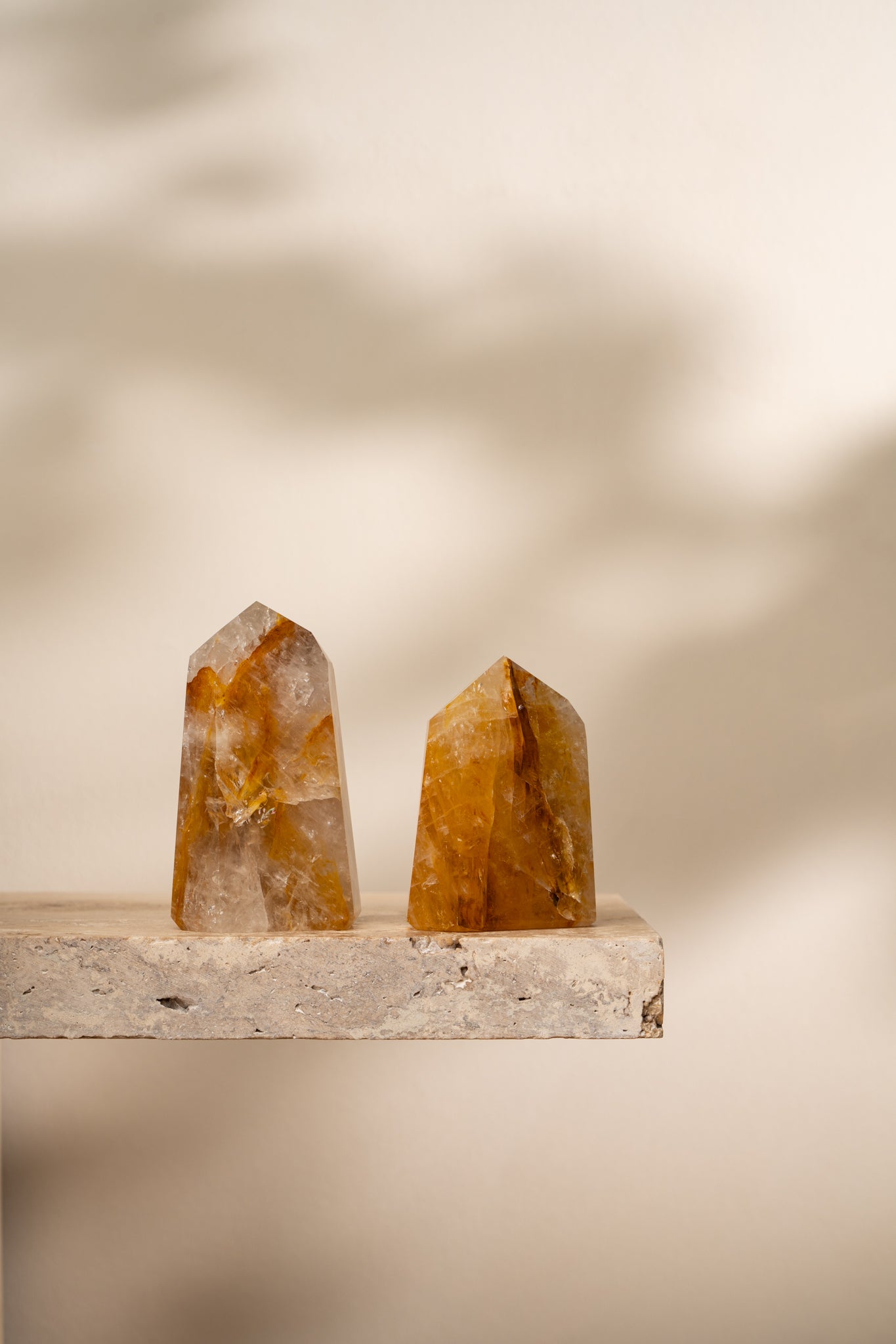 Two polished Hematoid Quartz towers with golden, red, and clear hues, featuring smooth, faceted surfaces that taper to a pointed top.